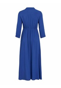 Modrá šaty s dlhými rukávmi, golierom a elastickým pásom. Vyrobené z hladkej tkaniny, maxi dĺžky a so zberaným dizajnom na chrbte.