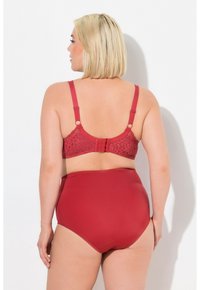 Rode kanten beha met verstelbare bandjes en een haak-en-oog sluiting aan de achterkant, gecombineerd met een effen rode hooggeplaatste bikini onderkant.