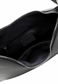 Svart läderväska med dragkedjestängning och silverfärgad hårdvara. Inuti finns en slät tygfoder och en liten ficka med dragkedja.