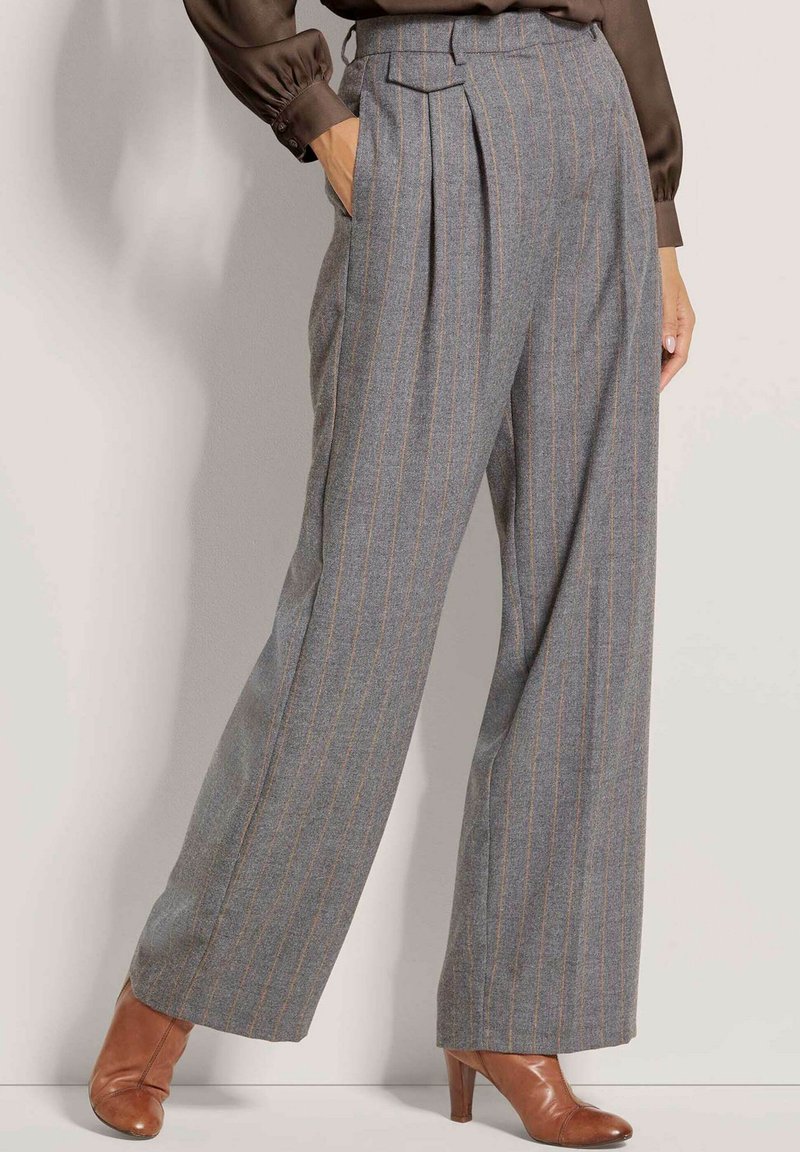 Grijze geblokte broek met een hoge taille, wijde benen en subtiele oranje strepen, gemaakt van structuurstof, gestyled met bruine hakken.