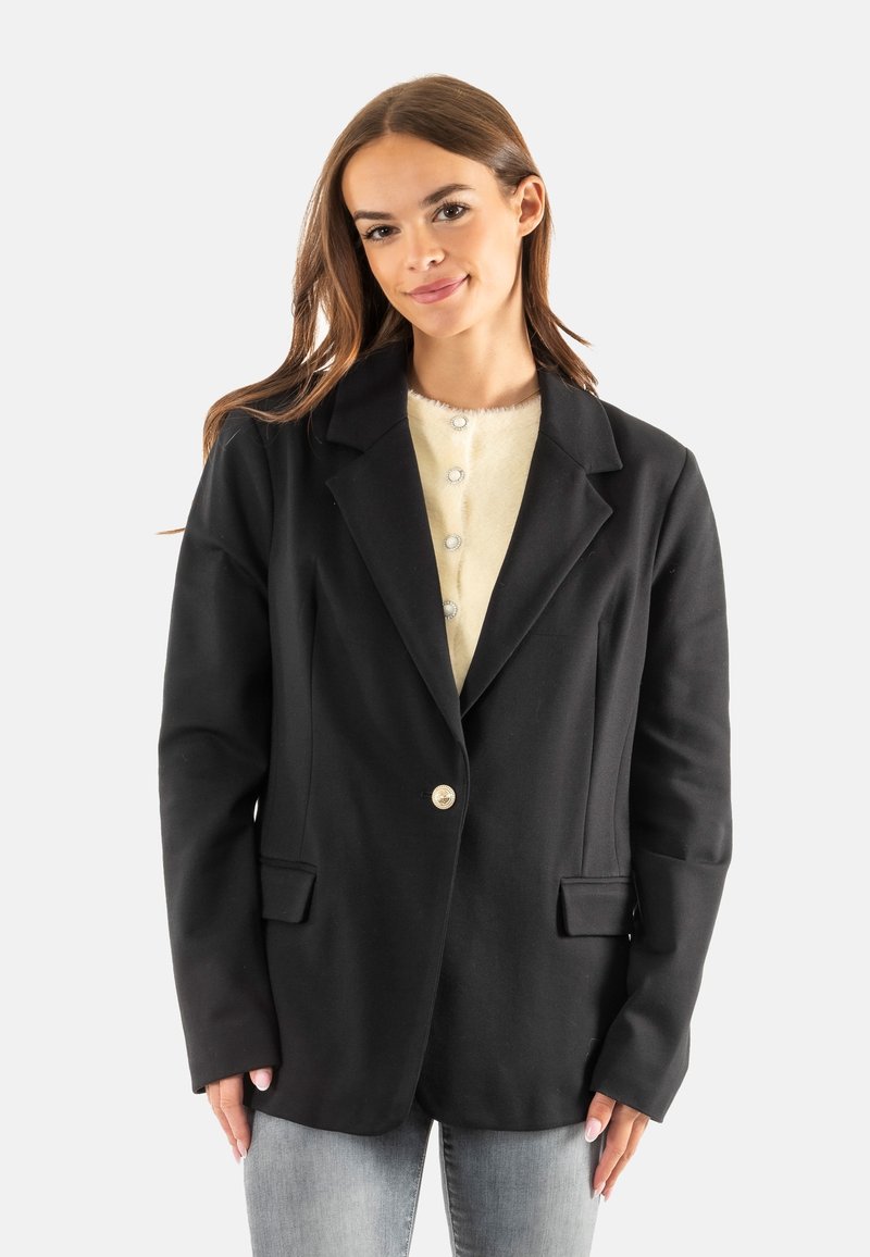Blazer negro con un diseño ajustado, cierre de un solo botón, solapas con muesca y dos bolsillos frontales, combinado con una blusa crema con botones.