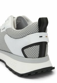 Athletic sneaker, gray mesh upper, white and black accents, padded collar, textured rubber sole, featuring logo on lateral side.