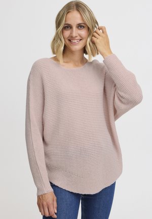 Maglione lavorato a maglia rosa chiaro con un ampio scollo e maniche lunghe e morbide. Presenta un motivo testurizzato e un orlo leggermente curvato.