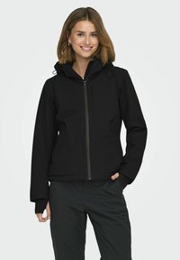 Veste à zip noir avec capuche, présentant une texture lisse, des poches avant et des poignets élastiques. Conçue pour une silhouette ajustée.