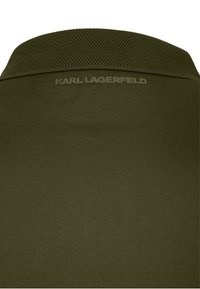 Olivgrünes Poloshirt mit strukturiertem Kragen und eingeprägtem "Karl Lagerfeld"-Logo unter dem Kragen.