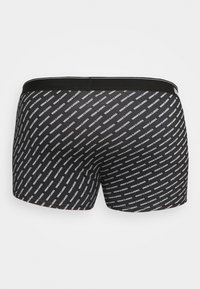 Fekete boxer alsónadrág, ismétlődő fehér "Urban Classics" szövegmintával. Puha anyag, rugalmas derékpánt és passzos fazon.