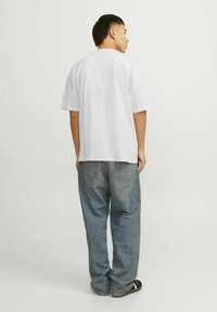 Witte katoenen T-shirt met korte mouwen en een relaxte pasvorm, gecombineerd met lichtblauwe denimjeans met een vijf-pocket ontwerp.