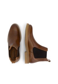 Bruine leren enkelschoenen met elastische zijpanelen, contrasterende zool en een trekband op de hiel. Soepele textuur en klassiek ontwerp.