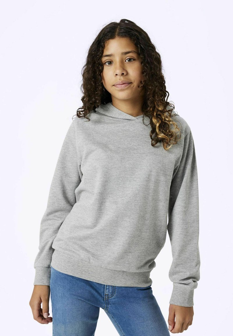 Haut de survêtement gris en tissu doux, avec une poche kangourou, un ourlet arrondi et des manches longues. Porté avec un jean bleu.