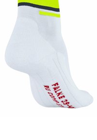 Białe skarpetki sportowe z żółtymi i czarnymi akcentami, z czerwonym napisem "FAKE 58" na podeszwie. Gładka, dziana tekstura, krótki fason do kostki.