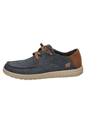 Zapatos de tela azul con acentos de ante marrón, cordones planos, suela acolchada y diseño de punta redondeada. Presenta un logo en el lateral.