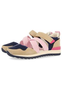 Zapatillas deportivas con ante beige, correas elásticas rosas y paneles de malla azul marino. Presenta una suela de goma texturizada y acentos rosa contrastantes.