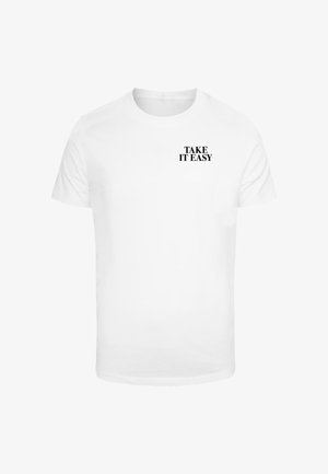 Witte katoenen t-shirt met korte mouwen, voorzien van de tekst "TAKE IT EASY" in vetgedrukte zwarte letters op de bovenste linkerborst.