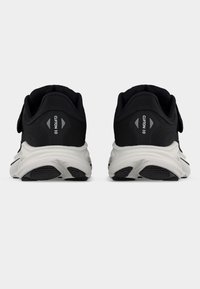 Ζευγάρι ασπρόμαυρα αθλητικά παπούτσια με ετικέτα «Clifton 10» στη φτέρνα, εμφανιζόμενα από πίσω σε λευκό φόντο.