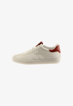 White leather sneaker with red accent at heel, leather texture, round toe, and stitched detailing along the sides and sole.
