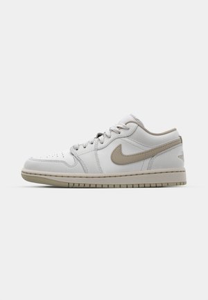 Madala nokatsneaker valge nahast ülaosaga, beežite aktsentidega, perforeeritud varbaga ja tekstureeritud kreemja välispõhjaga. Omab paelte kinnitust ja logo detaili.