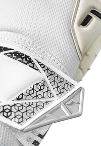 Witte sporthandschoen van gestructureerde stof met een zwart geometrisch patroon, versterkte accenten en een veilige band voor een goede pasvorm.