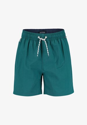 Turkooise zwemshorts met elastische taille, witte en zwarte trekkoord, zijzakken en een label met "BLUE SEVEN" aan de binnenzijde van de tailleband.