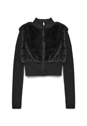 Schwarze, kurz geschnittene Jacke mit Reißverschluss, gerippten Strickärmeln und einem Kunstfelloberteil. Die Textur kontrastiert zwischen glatten und gerippten Stoffen.