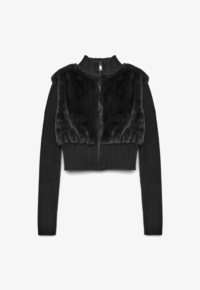 Schwarze, kurz geschnittene Jacke mit Reißverschluss, gerippten Strickärmeln und einem Kunstfelloberteil. Die Textur kontrastiert zwischen glatten und gerippten Stoffen.