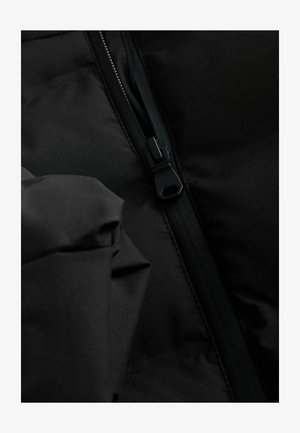 Černá vyp padded bunda z látky s viditelným zipem. Materiál vypadá hladce a matně, s elegantním, minimalistickým designem a skrytými švy.
