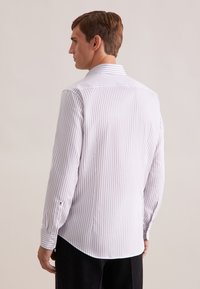 Camicia a maniche lunghe di colore grigio chiaro con sottili strisce verticali bianche. Presenta un colletto classico, polsini con bottoni e un orlo curvo.