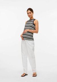 Randig svart och vit tanktop med en åtsittande design, kombinerad med lösa vita byxor och svarta flip-flops. Enkla accessoarer med örhängen.