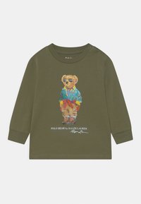 Olivegrön långärmad skjorta med en björngrafik i solglasögon och jacka. Inkluderar logotext under illustrationen.