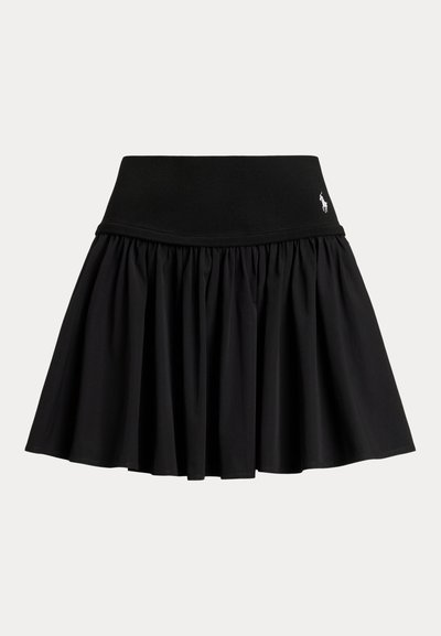 Svart plissett skjørt med bred elastisk midjebånd og liten hvit logo på høyre side av livet.