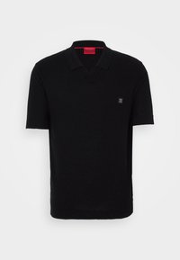 Zwarte polo met korte mouwen en V-hals, gemaakt van een gladde breimateriaal. Kenmerkt zich door een klein logo op de borst en een contrasterend rood label aan de binnenkant.