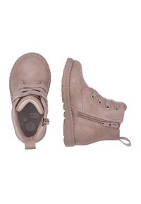 Stivali ankle in pelle color tan, con punta rotonda, lacci frontali, zip laterale e suola in gomma texture. Caratterizzati da dettagli cuciti e un tab per il collo.