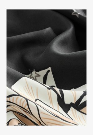 Mustvalge lillemuster kangas sujuva tekstuuriga, millel on stiliseeritud lehed ja tähed, elegantselt voolates pehmete voldidega.