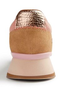 Sneaker con una toma in suede rosa e beige, dettagli metallici color oro rosa sul tallone e una suola in gomma rosa con una finitura testurizzata.