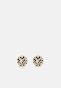 Cercei cu studs în ton de aur, având un centru de cristal transparent, înconjurat de un design circular negru și auriu cu inscripția "DKNY".