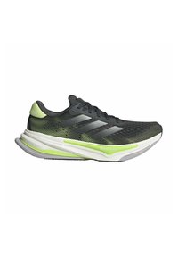 Scarpa da corsa nera con tomaia in mesh, dettagli verdi e intersuola bianca. Presenta una forma elegante e aerodinamica e una suola testurizzata per una maggiore aderenza.