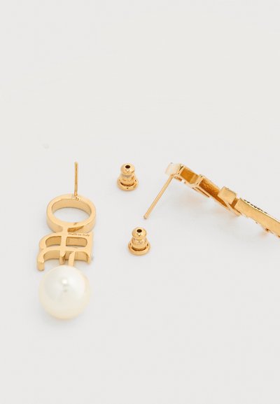 Χρυσά καρφωτά σκουλαρίκια με λεπτομέρεια από μαργαριτάρι και δύο χρυσά πίσω μέρη σε σχήμα πεταλούδας σε λευκό φόντο.