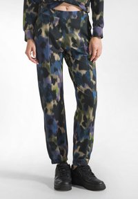 Multikleurige, gestreepte broek in donkere tinten met groen, blauw en paars. Losse pasvorm, met opgerolde enkels, gemaakt van een zachte, gestructureerde stof.