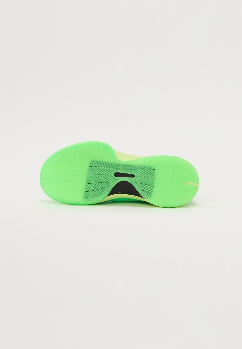Suela de goma verde con patrón de espiga y un acento central negro. Textura suave con forma redondeada, diseñada para ofrecer tracción.