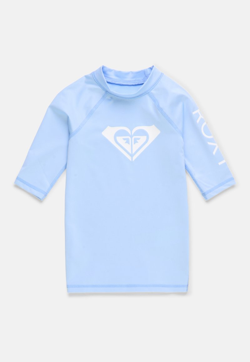 T-shirt rash guard à manches courtes bleu clair, fabriqué dans un tissu lisse et extensible, avec un logo en forme de cœur blanc sur le devant et le texte "ROXY" sur la manche.