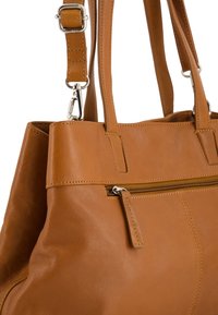 Braune Lederhandtasche mit strukturiertem Design, ausgestattet mit einer Reißverschlusstasche und einem verstellbaren Riemen. Glatte Textur und dezente Stichdetails.