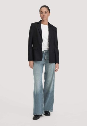 Zwarte blazer met geknipte revers, gecombineerd met een wit T-shirt en lichtblauwe wijde jeans. Glad materiaal, gestructureerd ontwerp, casual pasvorm.