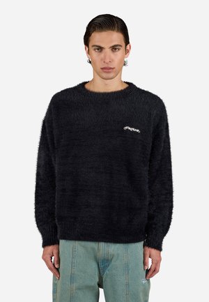 Oversized black knit sweater with a soft, fuzzy texture. Features a ribbed neckline and cuffs, and a white logo on the chest.