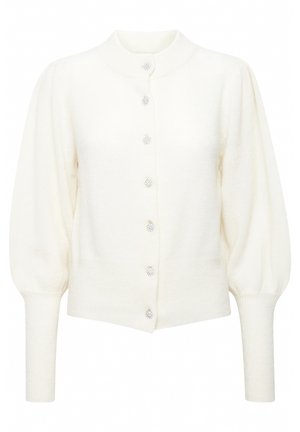 Krämfärgad kofta med rund krage, puffärmar och sju dekorativa kristallknappar framtill. Mjuk, strukturerad tyg.