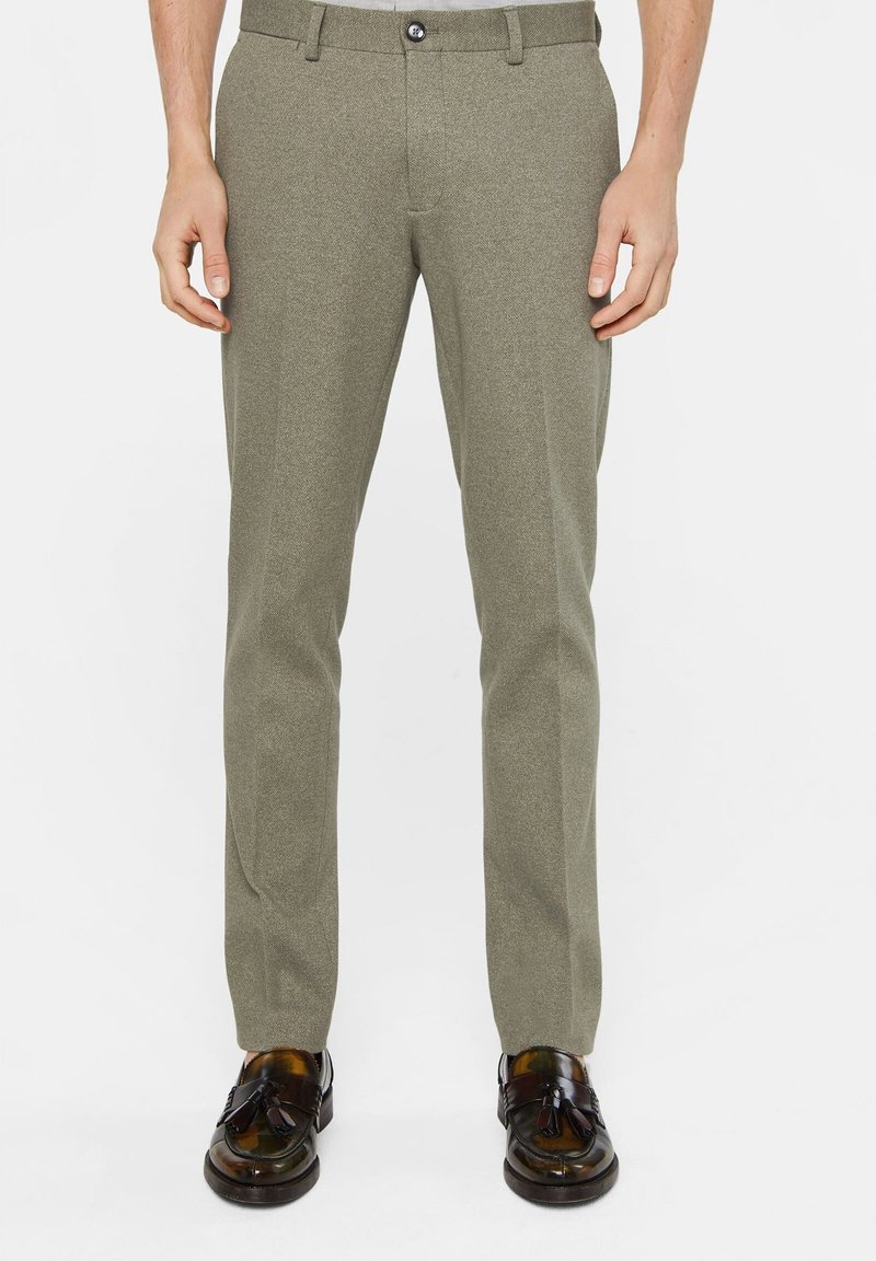 Skärpbyxor i strukturerad olivgrön tyg. Har en slät front, standard midja och traditionell dragkedja med knappstängning.