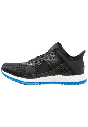 Chaussure de sport noire et grise avec lacets noirs, semelle intermédiaire blanche et semelle extérieure bleue texturée, vue de profil sur fond blanc.