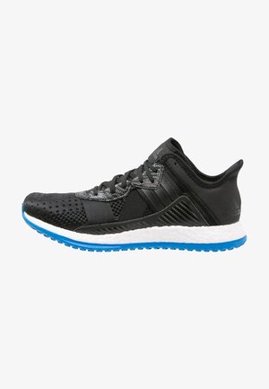 Chaussure de sport noire et grise avec lacets noirs, semelle intermédiaire blanche et semelle extérieure bleue texturée, vue de profil sur fond blanc.