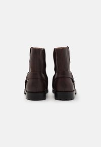 Brown leather ankle boots with a smooth finish, contrast stitching, and a side zip closure. Features a sturdy black rubber sole.