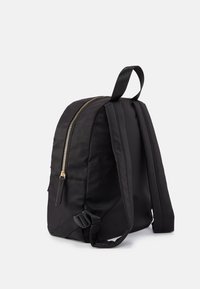 Mochila negra de nailon con una textura suave, que presenta una cremallera dorada, correas de hombro acolchadas y un asa de transporte superior.