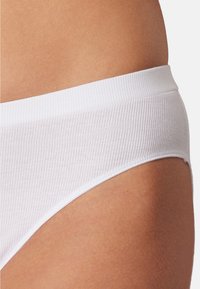 Un slip en coton côtelé blanc avec une taille lisse. Le design est ajusté, avec une texture subtile et des bords sans couture pour le confort.