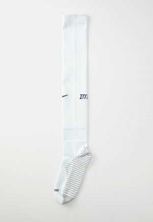 Chaussette de sport hauteur genou en bleu clair avec une texture côtelée. Présente une section de pied rayée en gris et blanc ainsi qu'un logo bleu foncé.
